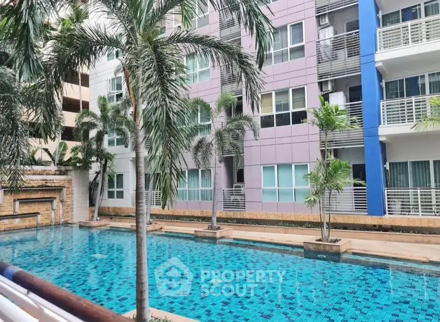 Modern apartment building with a stunning pool and palm trees, perfect for luxury living.