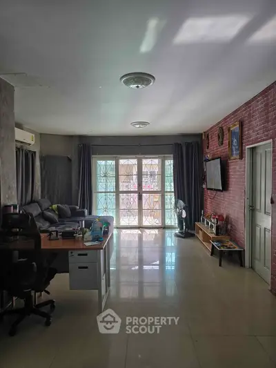 Spacious living room with modern decor and ample natural light, perfect for relaxation and entertainment.