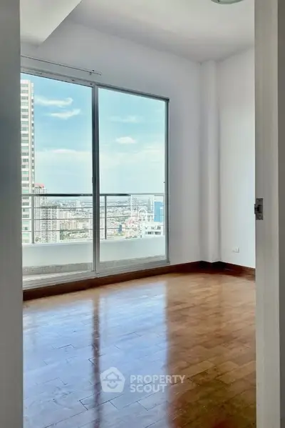 Spacious room with stunning city view and large windows in modern apartment.