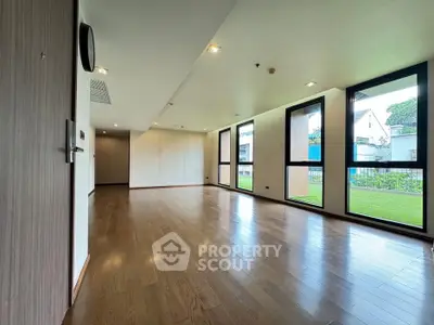 Spacious modern living room with large windows and wooden flooring