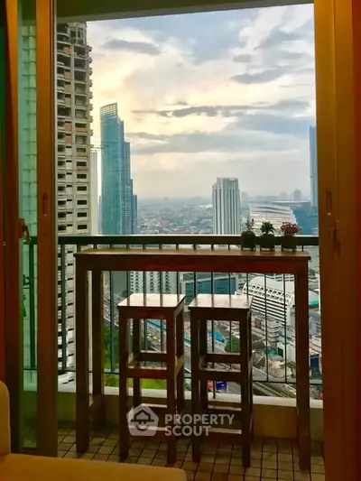 Stunning city view from a high-rise balcony with modern furniture.