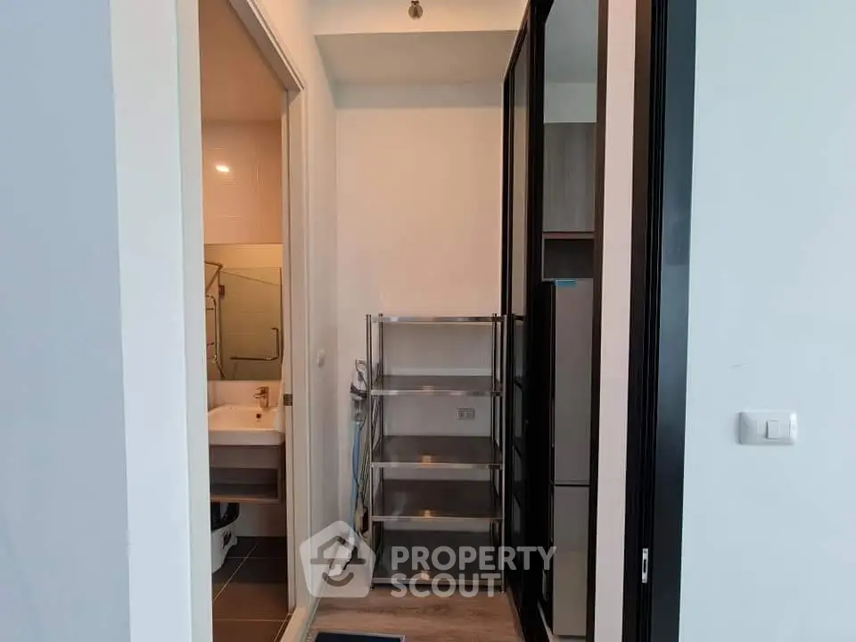 Compact apartment entryway with bathroom and storage shelves