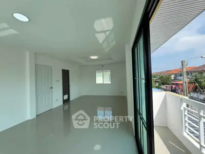 Spacious modern living room with large windows and balcony access, offering abundant natural light.
