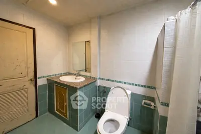 Spacious bathroom with modern fixtures and tiled walls, featuring a shower and toilet.
