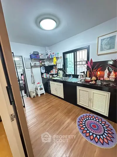 Charming kitchen with wooden flooring and open shelves, perfect for cozy home cooking.