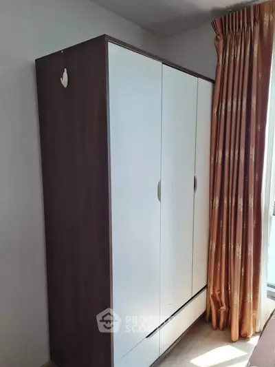 Modern wardrobe in a bright room with elegant curtains, perfect for stylish storage solutions.