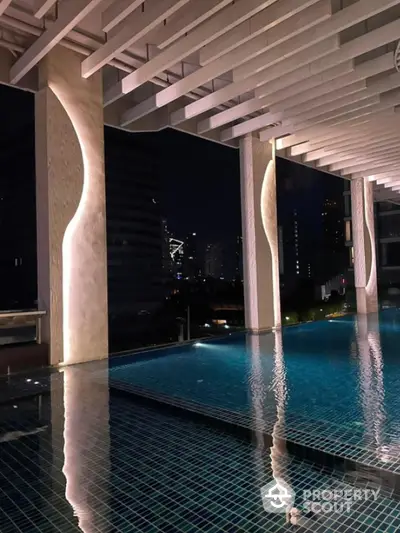 Luxurious rooftop pool with stunning night city view and modern architectural design.