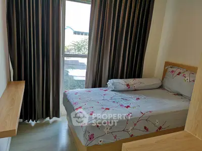 Cozy bedroom with floral bedding and large window offering natural light and a serene view.