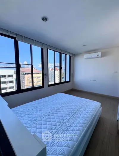 Bright bedroom with large windows and city view in modern apartment