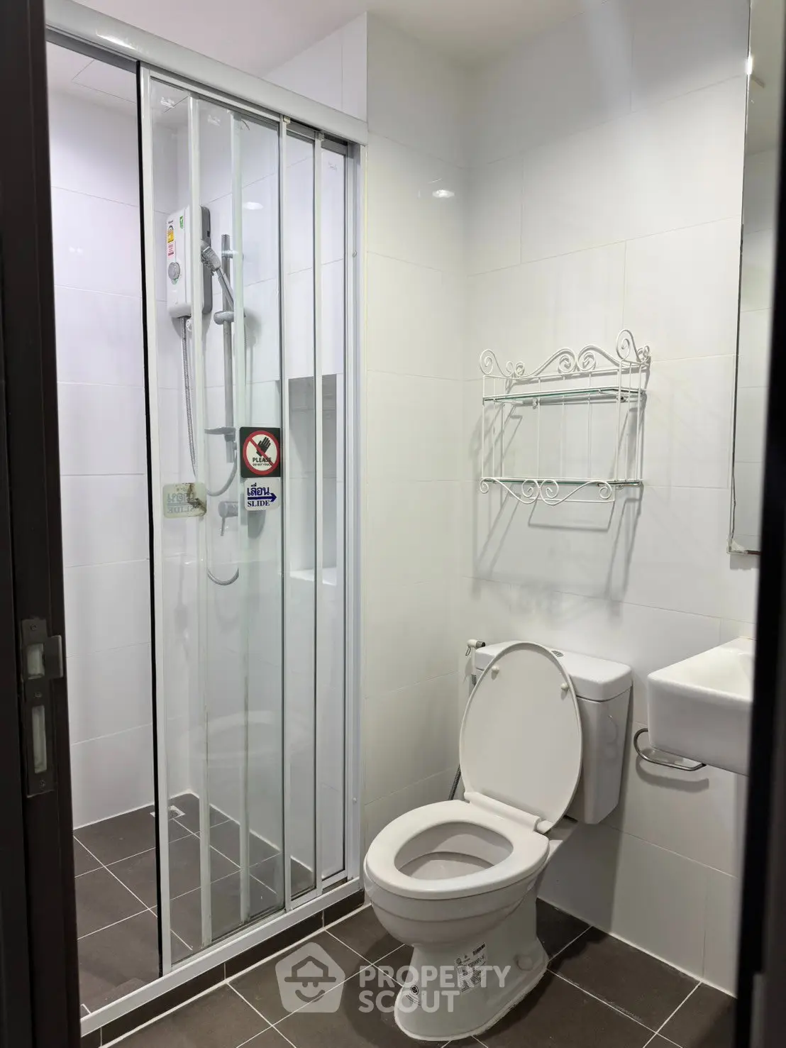 Modern bathroom with shower enclosure and white fixtures in sleek design.
