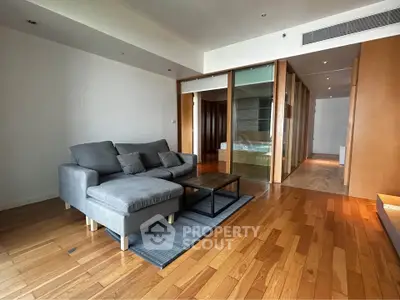 Spacious modern living room with wooden flooring and cozy gray sofa