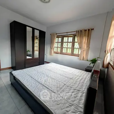 Spacious bedroom with large window and modern wardrobe, perfect for natural light lovers.