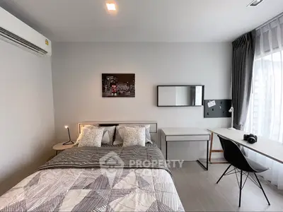 Modern bedroom with stylish decor, featuring a cozy bed, sleek desk, and ample natural light.