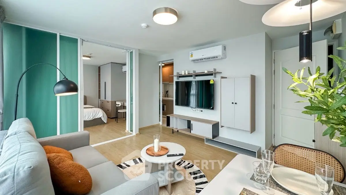 Modern living room with stylish decor and open layout, featuring a cozy sofa and elegant lighting.