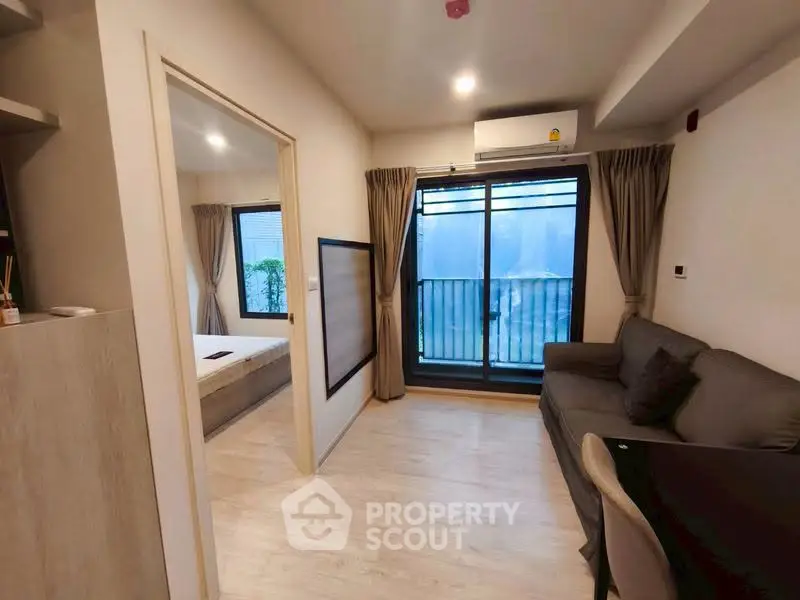 Modern apartment interior with cozy living room and bedroom, featuring large windows and elegant curtains.