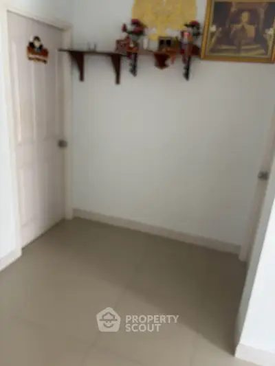 Cozy interior corner with tiled floor and decorative wall shelf, perfect for personalization.