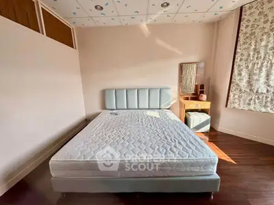 Spacious bedroom with modern bed and vanity set, featuring elegant decor and ample natural light.