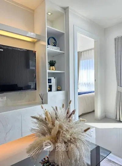 Modern living room with elegant decor and view into a cozy bedroom