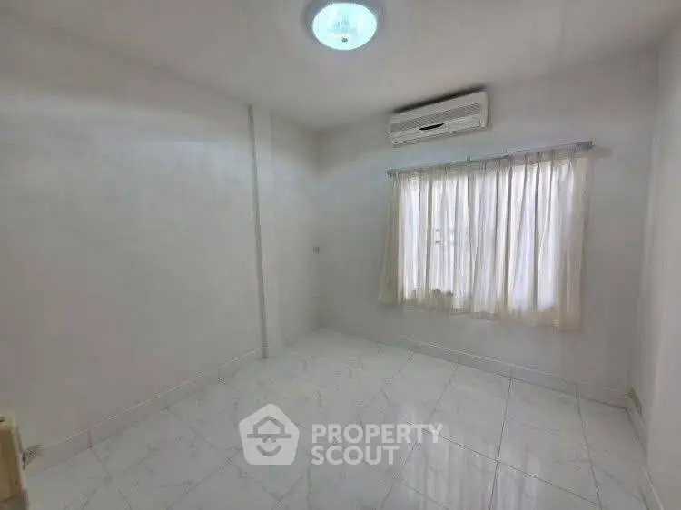 Bright empty room with air conditioning and tiled floor, perfect for customization.