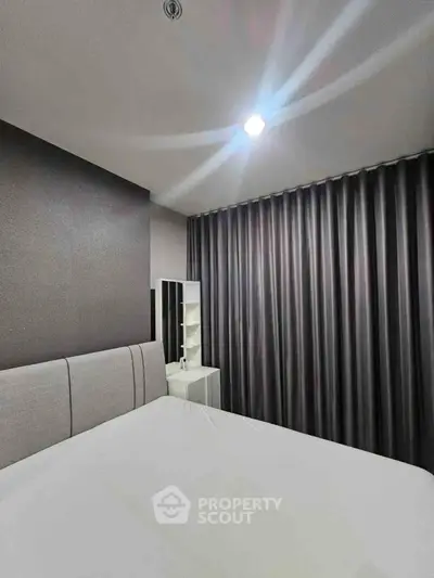 Modern bedroom with sleek design and elegant curtains, perfect for a cozy retreat.