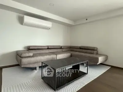 Modern living room with sleek sectional sofa and minimalist coffee table, perfect for contemporary living.