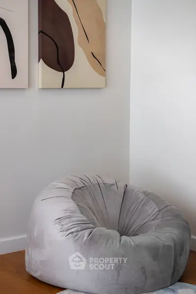 Cozy corner with a plush bean bag and abstract art, perfect for relaxation.