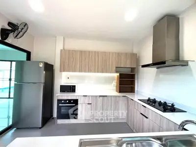 Modern kitchen with sleek appliances and open layout, featuring gas stove and ample storage.