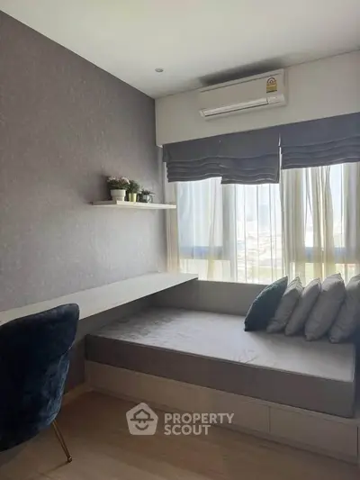 Cozy study room with built-in desk and daybed, featuring large windows and modern decor.