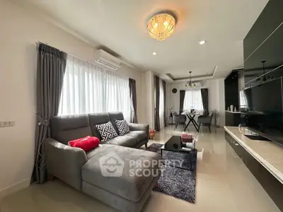 Stylish modern living room with elegant decor and open dining area.