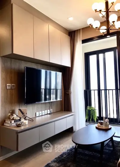 Modern living room with sleek TV setup and elegant lighting, featuring a cozy balcony view.
