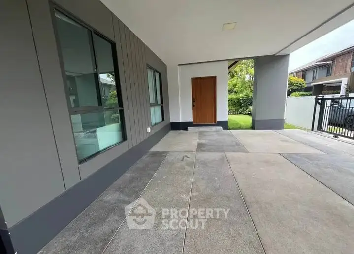 Modern home entrance with spacious covered area and sleek design.