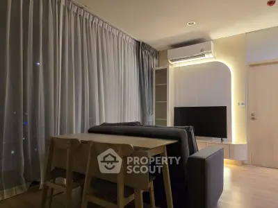Modern living room with stylish furniture and ambient lighting, featuring a sleek TV setup and elegant curtains.