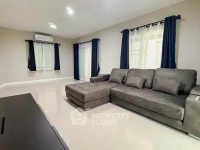 Spacious living room with modern gray sectional sofa and large windows for natural light.