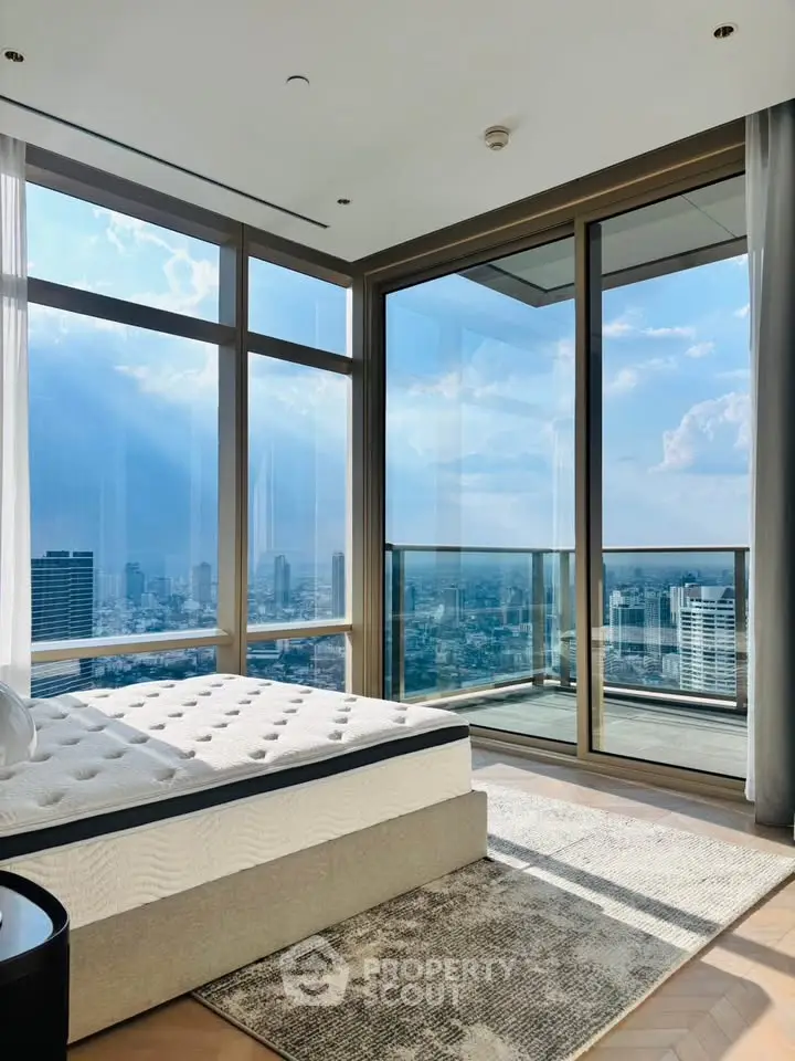 Luxurious bedroom with floor-to-ceiling windows offering stunning city views and abundant natural light.