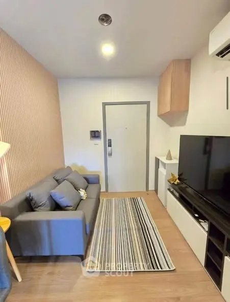 Modern living room with sleek furniture and striped rug, perfect for cozy relaxation.