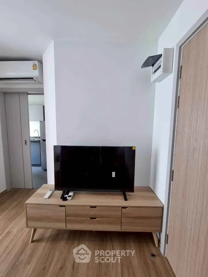 Modern living room with sleek TV stand and wooden flooring in a stylish apartment.