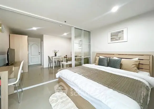 Spacious modern bedroom with elegant decor and sliding glass doors leading to dining area.