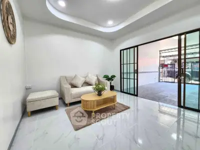 Spacious living room with modern decor and sliding glass doors leading to a covered patio.
