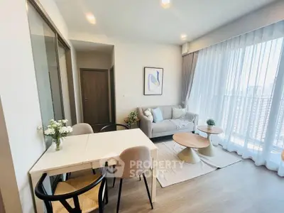 Modern living room with stylish decor and large windows offering natural light.