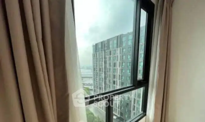 Stunning view from a high-rise apartment window overlooking modern cityscape.