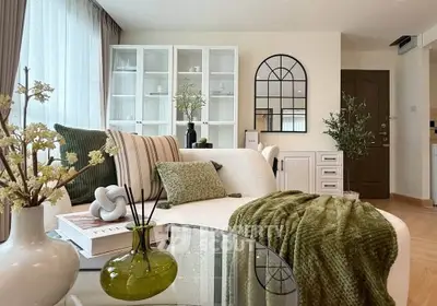 Stylish living room with modern decor, plush sofa, and elegant glass table in a bright, airy space.