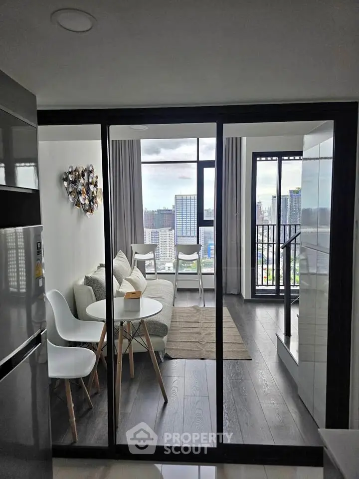 Modern living room with city view and balcony access in high-rise apartment