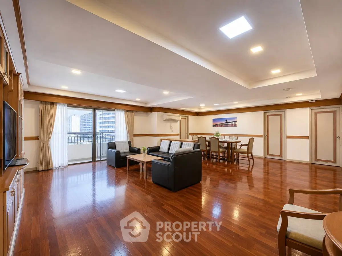 Spacious living room with wooden flooring and modern furniture in a luxury apartment.