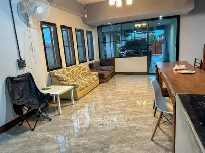 Spacious living room with modern furniture and large windows overlooking driveway