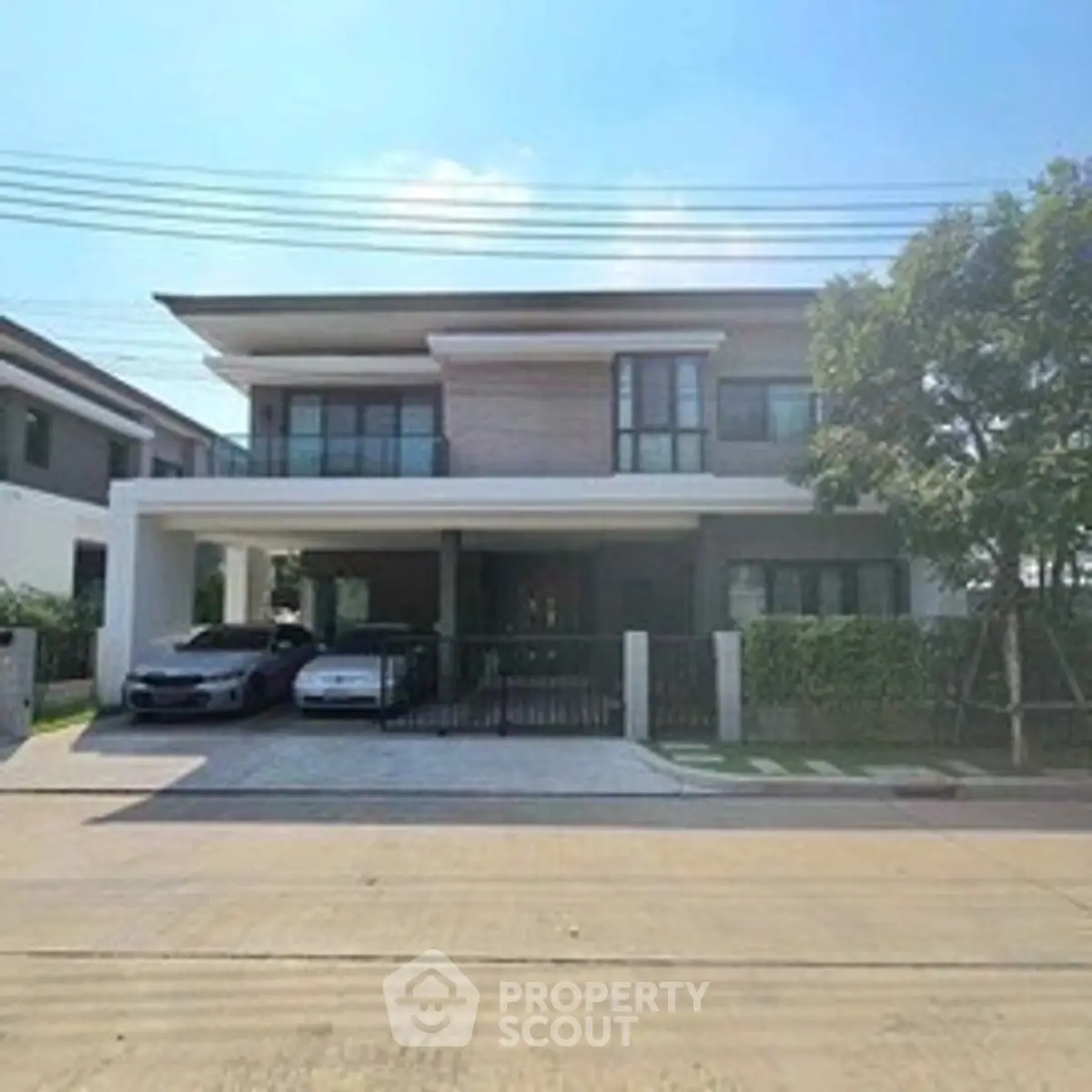 Modern two-story house with spacious driveway and lush greenery