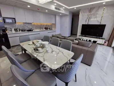 Luxurious open-plan living room and kitchen with marble finishes and modern decor.