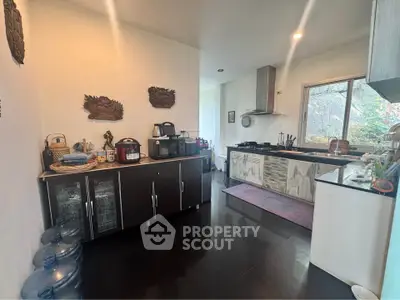 Spacious kitchen with modern appliances and ample storage, featuring a sleek design and natural light.