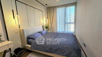 Modern bedroom with stylish decor and large window for natural light.
