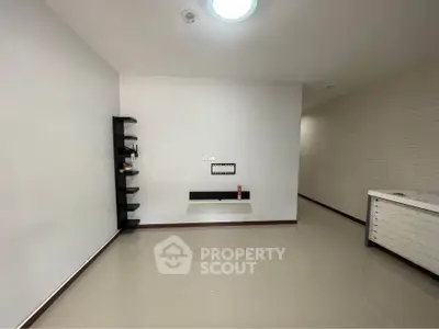 Spacious empty room with sleek shelves and modern lighting, perfect for customization.