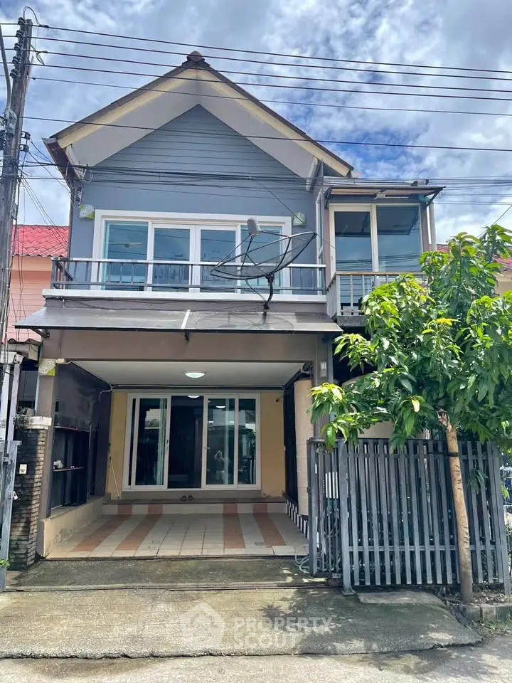 Charming two-story house with gated entrance and spacious driveway, perfect for family living.